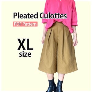 May include: A pair of tan pleated culottes in XL size, shown with a bright pink short-sleeved top and black boots. The image includes the text Pleated Culottes, PDF Pattern, and XL size, indicating a sewing pattern for these wide-leg trousers.