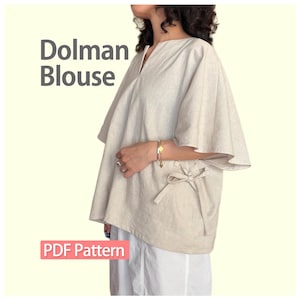 Könnte beinhalten: Eine beige Dolman-Bluse mit V-Ausschnitt, weiten kurzen Ärmeln und einer seitlichen Bindung. Der Text 'Dolman Blouse' und 'PDF Pattern' ist auf dem Bild zu sehen. Das Kleidungsstück wird über einer weißen Hose getragen und hat eine lockere Passform.