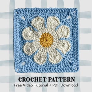 Puede incluir: Un patrón de crochet cuadrado con un diseño de margarita. La margarita tiene pétalos blancos y un centro amarillo, sobre un fondo azul claro. El texto "CROCHET PATTERN" está en la parte inferior, con texto adicional debajo.