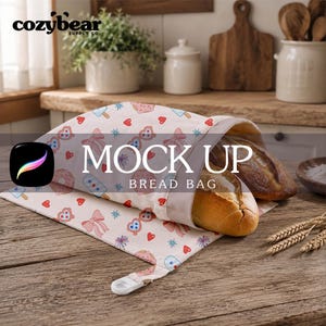 May include: A fabric bread bag featuring a repeating pattern of pink bows, red hearts, blue star-shaped sunglasses, and popsicles on a cream background. The bag is open, revealing two crusty loaves of bread inside, and has a white plastic toggle closure.
