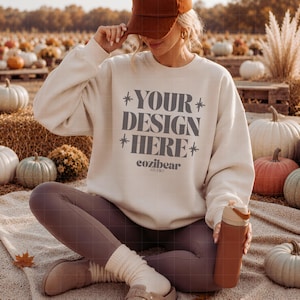 Könnte beinhalten: Ein beiges Sweatshirt mit Rundhalsausschnitt und dem dunkelgrauen Text YOUR DESIGN HERE mit Sternakzenten sowie dem darunter gedruckten Wort cozibear STUDIO. Das Sweatshirt wird mit braunen Leggings, beigen Socken, braunen Schuhen und einer braunen Kappe getragen.