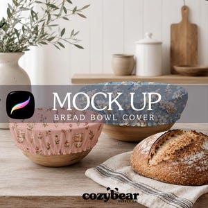 May include: Two round fabric bread bowl covers with elastic edges. One cover is dusty pink with a small floral and teacup pattern, while the other is blue with a dense white floral print. A loaf of bread sits on a striped cloth nearby.
