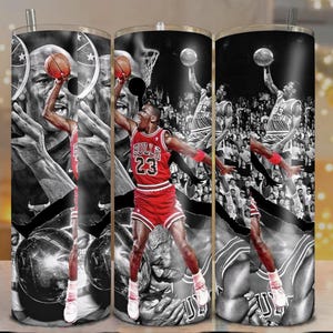 May include: A set of three stainless steel tumblers featuring a black and white collage of a basketball player in action. The player is wearing a red jersey with the number 23. The tumblers have a silver straw and a black and white background.