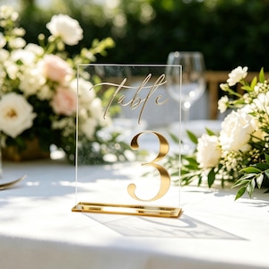 Helder acryl bruiloft tafelnummers met gouden spiegelstandaard, modern receptietafeldecor, elegant tafelstuk bruiloft, tafelnummerset