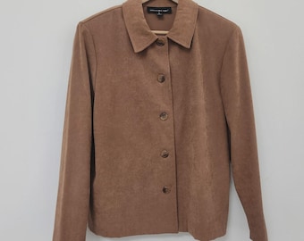 Könnte beinhalten: Eine braune Jacke mit Knöpfen und Kragen, die an einem Holzbügel hängt. Die Jacke hat lange Ärmel und eine Wildleder-ähnliche Textur. Die Knöpfe haben eine passende braune Farbe.