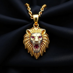 May include: A gold-colored lion pendant necklace with a detailed lion's head. The lion has red gemstone eyes and a red gemstone in its open mouth. The necklace chain is also gold-colored, and the background is black.