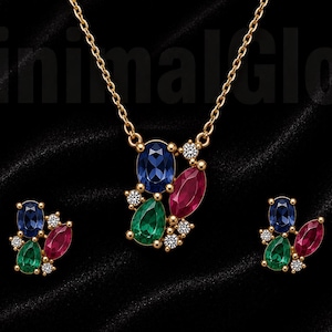 May include: A gold-toned necklace and matching earring set featuring clusters of oval-cut blue, pear-cut green, and marquise-cut red gemstones accented with small clear stones. The text MinimalGlow is visible in the background of this jewelry set.