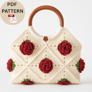 May include: Cream-coloured crochet handbag with a wooden handle and red rose embellishments. The bag features a diamond pattern and is adorned with six red roses with green leaves. The text "PDF PATTERN" is in a circle at the top left.