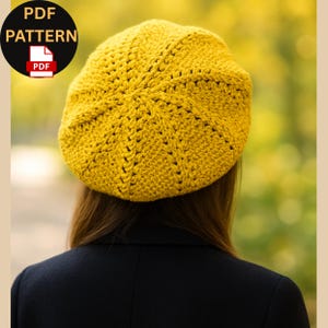 Può includere: Un basco all'uncinetto giallo senape, visto da dietro, con un motivo strutturato che emana dal centro. Il basco è ambientato su uno sfondo naturale sfocato. Un cerchio nero con il testo "PDF PATTERN" e un'icona PDF si trova nell'angolo in alto a sinistra.