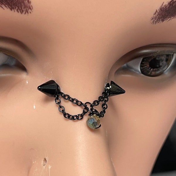 Nose bridge iercing jewelry with black chains and faceted glass bead, spike ends