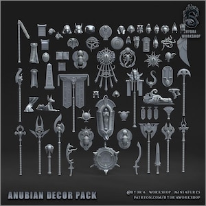 Könnte beinhalten: Eine Sammlung grauer Dekorationsstücke zum Thema Anubis, darunter Statuen, Schilde und Waffen. Das Set zeigt verschiedene ägyptisch inspirierte Designs, wie Skarabäen, Anchs und Pharaonen. Der Text "ANUBIAN DECOR PACK" ist unten sichtbar.