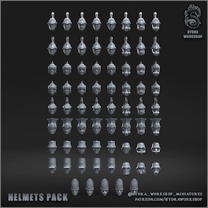 May include: A collection of grey miniature helmets arranged in a grid, featuring various designs including crested, gas mask, and flat-topped styles. The text "HELMETS PACK" and "HYDRA WORKSHOP" is visible. These small components are for hobbyist use.