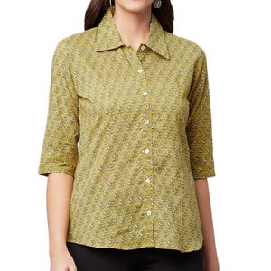 Peut inclure: Chemise boutonnée vert olive clair, ornée d'un motif floral répété blanc et gris. La chemise a un col classique et des manches trois-quarts. Le vêtement est en tissu léger.