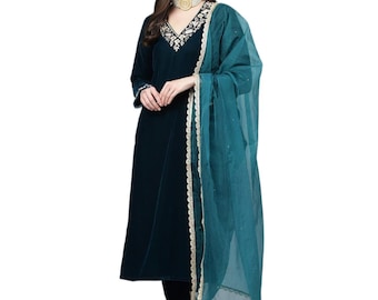 May include: A dark teal velvet long-sleeved kurta featuring a V-neckline with white floral embroidery, paired with a matching sheer teal dupatta that has a scalloped gold border. The ensemble includes a pearl choker necklace with a gold center.