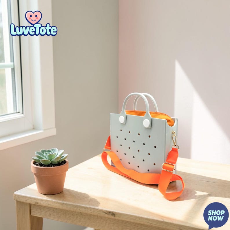 May include: A light gray tote bag with a bright orange shoulder strap and interior. The bag has a perforated design and white handles. A small potted succulent sits on a wooden table. The text "Luvetote" is in the upper left corner.