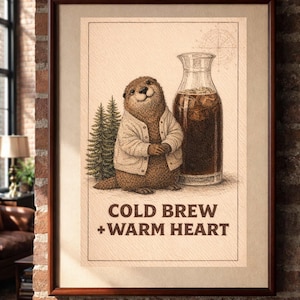 May include: Framed art print featuring a smiling otter wearing a sweater, with a glass carafe of cold brew coffee. The text "COLD BREW + WARM HEART" is displayed below the otter. The artwork is set against a neutral background.