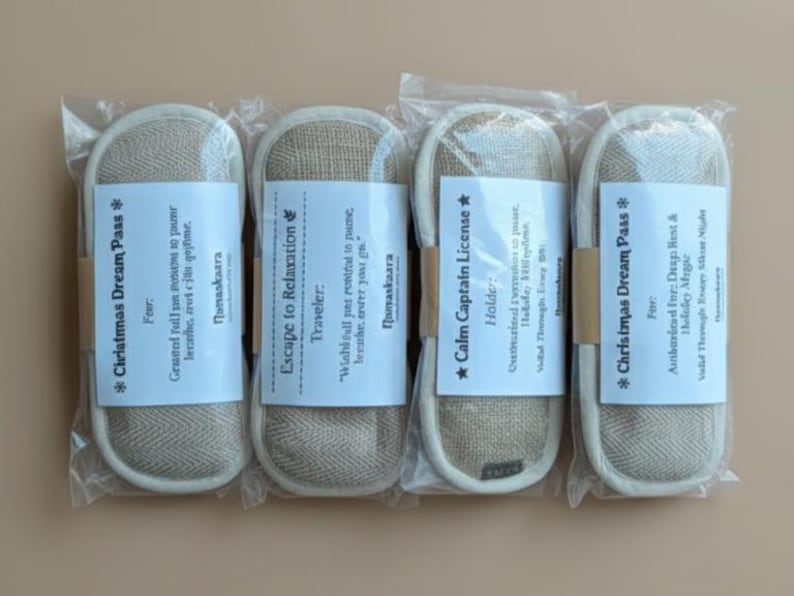 May include: Four packaged slippers with white labels. The labels have text that reads "Christmas Dream Pass", "Escape to Relaxation", and "Calm Captain License". The slippers are beige with a white border.