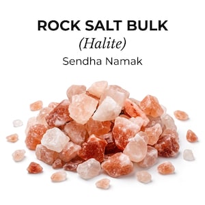 May include: A pile of raw rock salt crystals in shades of pink, orange, and white. The text above the crystals reads ROCK SALT BULK (Halite) Sendha Namak. The crystals are irregular in shape, translucent, and vary in size, forming a cluster.