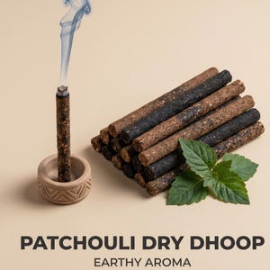 Puede incluir: Un palito de dhoop seco de pachulí encendido con humo, colocado en un soporte beige. Una pila de palitos de dhoop marrones y negros y hojas verdes están a la derecha. El texto en la parte inferior dice "PATCHOULI DRY DHOOP EARTHY AROMA."
