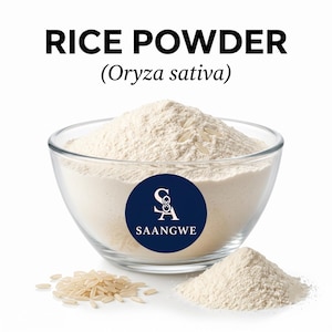 May include: A clear glass bowl filled with fine white rice powder, featuring a dark blue circular logo with the text SAANGWE and a stylized SA symbol. The text RICE POWDER (Oryza sativa) is displayed above the bowl, with loose rice grains placed nearby.