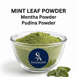 May include: A clear glass bowl filled with fine green mint leaf powder, labelled with the text MINT LEAF POWDER, Mentha Powder, Pudina Powder, and a circular blue logo with the letters SA and the word SAANGWE, accompanied by fresh mint leaves.