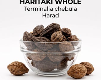 May include: A clear glass bowl filled with dried, dark brown, ridged Haritaki whole fruits, also known as Terminalia chebula or Harad. Three additional fruits are placed in front of the bowl on a white surface. The text reads HARITAKI WHOLE, Terminalia chebula, Harad.