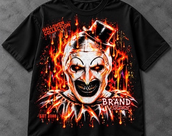 May include: A black t-shirt featuring a graphic of a clown wearing a top hat, surrounded by orange and yellow flames. The text HALLOWEN COLLECTION is printed in the upper left, and BRAND STUDIOS EST 2028 is printed in the lower right.