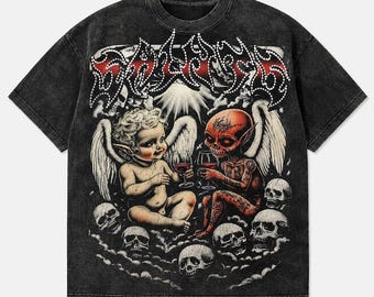 May include: A black acid-wash t-shirt featuring a graphic print of a cherub and a red-skinned demon with wings, both holding wine glasses. The design includes multiple skulls and the text "SAINT" in a stylized, studded font at the top.
