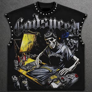 Puede incluir: Una camiseta negra sin mangas con el gráfico de un esqueleto con gorra y camiseta trabajando en un escritorio con botes de pintura en aerosol. La palabra Godspeed está impresa en grandes letras góticas en la parte superior. Tachuelas plateadas.