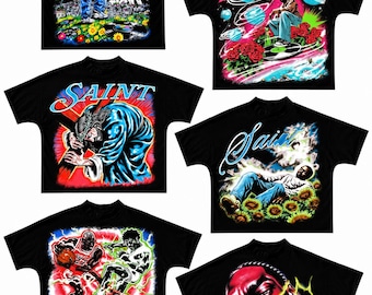 May include: A collection of six black short-sleeve t-shirts featuring vibrant, multi-colored graphic prints. The designs include figures, flowers, basketball players, and the text "Saint" or "Brand" in various stylized fonts and colors.