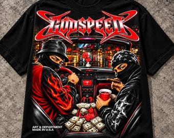 May include: A black t-shirt featuring a graphic print of two individuals in masks inside a car. The text GODSPEED is at the top. The design includes stacks of cash, red dice, a red cup, and a cigar. The text ART & DEPARTMENT MADE IN U.S.A is printed at the bottom left.