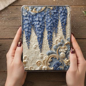 May include: A clear tablet case featuring a detailed floral design. The case has a cream-colored background with blue wisteria and gold accents. The design is three-dimensional, giving it a textured appearance.
