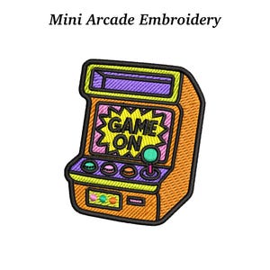 May include: Embroidered patch of a retro arcade game machine. The machine is orange with a purple top and a pink and yellow screen that says "GAME ON". It has a green joystick and buttons.