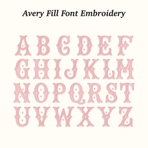 以下が含まれることがあります： Avery Fill Fontスタイルのピンク色の刺繍文字の完全なアルファベット。文字はクリーム色の背景に表示されます。「Avery Fill Font Embroidery」というテキストが画像の上部にあります。