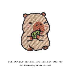 Peut inclure: Un motif de broderie représentant un capybara beige avec un museau marron, des joues roses et les yeux fermés, tenant une feuille verte. Sous le capybara, le texte indique : DST . EXP . HUS . JEF . PES . SEW . VP3 . XXX . EMB . PDF. PDF Embroidery Pattern Included.