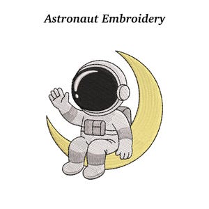 May include: An embroidered design featuring an astronaut waving while seated on a yellow crescent moon. The astronaut is wearing a white spacesuit with a black visor. The text "Astronaut Embroidery" is above the design.