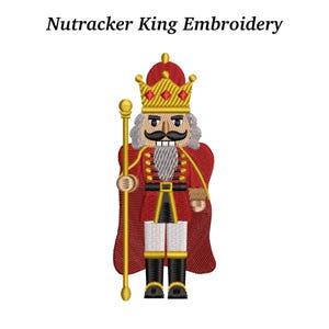 May include: An embroidered image of a Nutcracker King, featuring a red cape and uniform, a gold crown, and a staff. The text "Nutcracker King Embroidery" is above the image. The design is detailed with black, gold, and white accents.