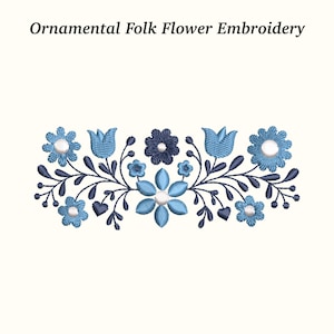 Puede incluir: Diseño de bordado floral folclórico ornamental, con una disposición simétrica de flores y hojas azules, con detalles blancos, sobre un fondo crema. El diseño utiliza varios tonos de azul. El texto "Ornamental Folk Flower Embroidery" está en la parte superior.