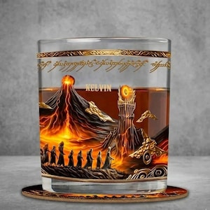 May include: A clear glass with a detailed, fantasy-themed design. The artwork features a volcano, a tower, and figures walking in a line, all in shades of orange and gold. The word "KELVIN" is printed on the glass.