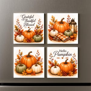 May include: Four square magnets featuring autumn themes with pumpkins, fall foliage, and berries. Two magnets include text: one reads Grateful Thankful Blessed, and the other reads Hello Pumpkin. The designs incorporate orange, white, and green pumpkins.