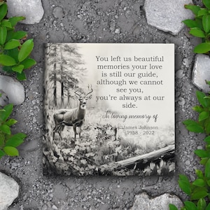 May include: A black and white memorial stone with a deer in a forest scene. The text reads: "You left us beautiful memories your love is still our guide, although we cannot see you, you're always at our side. In loving memory of James Johnson 1958-2022"