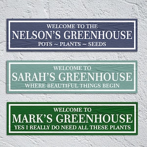 May include: Three wooden signs with white text on a textured background. The top sign is blue and says "Welcome to the Nelson's Greenhouse Pots ~ Plants ~ Seeds". The middle sign is green and says "Welcome to Sarah's Greenhouse Where Beautiful Things Begin". The bottom sign is green and says "Welcome to Mark's Greenhouse Yes I Really Do Need All These Plants".