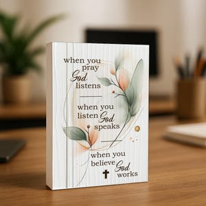 May include: A rectangular canvas art piece with the text "when you pray God listens, when you listen God speaks, when you believe God works." The artwork features watercolor-style floral accents in shades of peach and green.