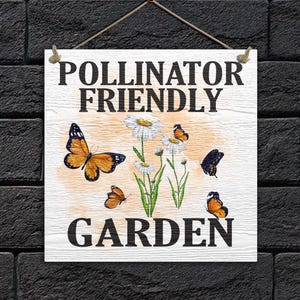 May include: White wooden sign with the text "Pollinator Friendly Garden" in black lettering. The sign features a watercolor illustration of daisies and butterflies.