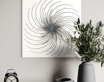 May include: A white square wall art piece with a spiral design in black and gray. A black alarm clock, a gray bowl, and a gray vase with greenery are on a gray surface.
