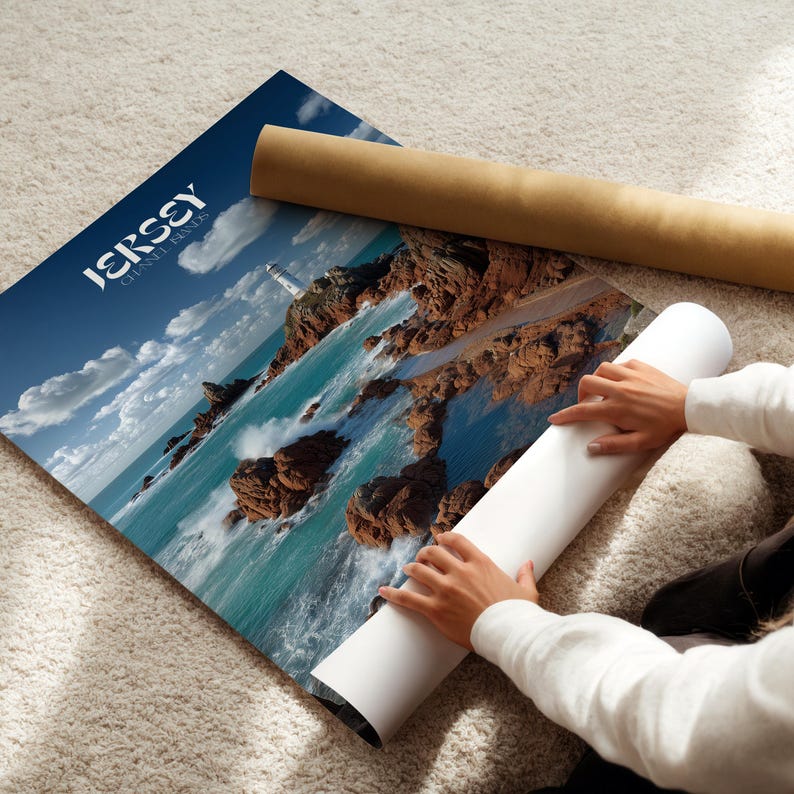 May include: A poster depicting a coastal scene with the words "JERSEY CHANNEL ISLANDS" in white. The image shows a lighthouse, rocks, and turquoise water under a blue sky. A rolled-up poster and a brown tube are also visible.