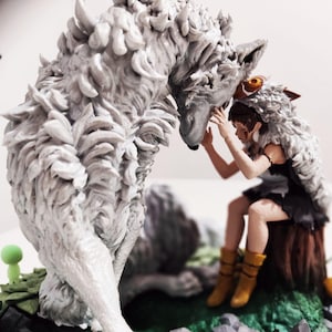 May include: A detailed figurine depicting a wolf and a person. The wolf is large and gray with textured fur. The person is seated, wearing a fur-trimmed hood and a black dress. The scene is set on a base with green and gray elements.