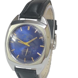 Pode incluir: Um rel&oacute;gio de pulso vintage com caixa prateada e mostrador azul. O rel&oacute;gio apresenta ponteiros e marcadores dourados e uma bracelete de couro preta. O mostrador diz "FAVRE-LEUBA GENEVE" e "17 JEWELS SHOCKPROOF".