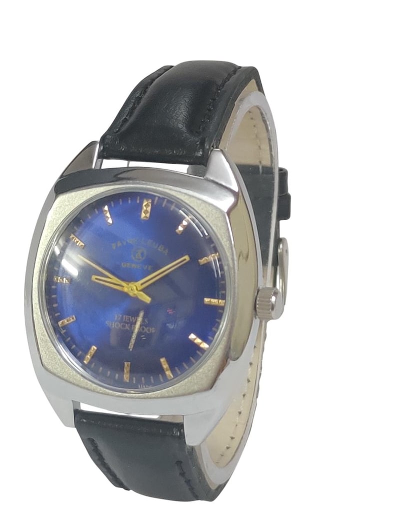 Pode incluir: Um rel&oacute;gio de pulso vintage com caixa prateada e mostrador azul. O rel&oacute;gio apresenta ponteiros e marcadores dourados e uma bracelete de couro preta. O mostrador diz "FAVRE-LEUBA GENEVE" e "17 JEWELS SHOCKPROOF".