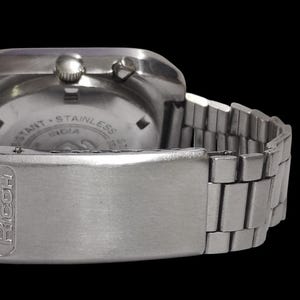Pu&ograve; includere: Un orologio da polso in acciaio inossidabile argentato con cinturino e chiusura in metallo. Il quadrante dell'orologio &egrave; visibile, con la scritta "RESISTANT - STAINLESS INDIA". La chiusura &egrave; incisa con il nome "FACOH".
